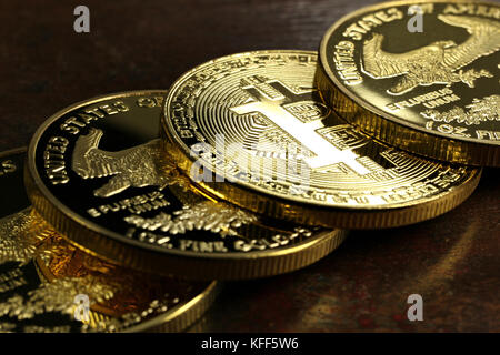 Bitcoin in einer Reihe von 1 Unze american Gold Eagle Bullion Coins Stockfoto