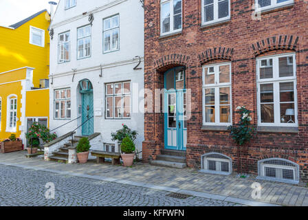 Gebäude und Häuser mit Eingang mit Treppe zur Strasse in der Küstenstadt Husum an der Nordsee, Deutschland Stockfoto