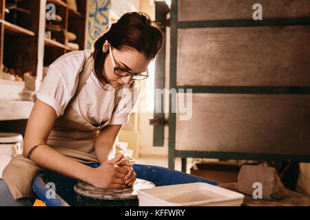 Frau molding Clay auf Keramik Rad. Handwerkerin, Topf in der Werkstatt. Stockfoto