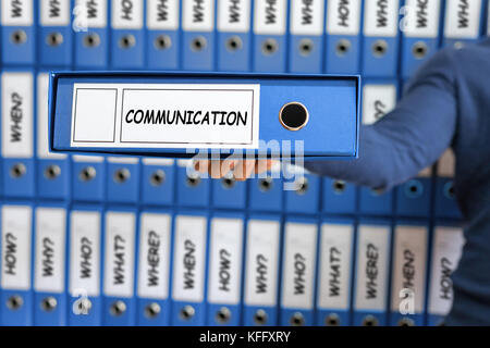Was, Wo, Wer, Warum, Wann, Wie? Junger Mann mit Ring Binder. Stockfoto