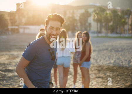 Porträt der Mann glücklich lachend auf Strand mit Freunden Stockfoto