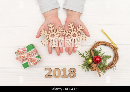 Weihnachten Kalender auf weißem Hintergrund. Child's Hände, die Christmas Ball in der Nähe von geschenkboxen auf weißen Tisch Stockfoto