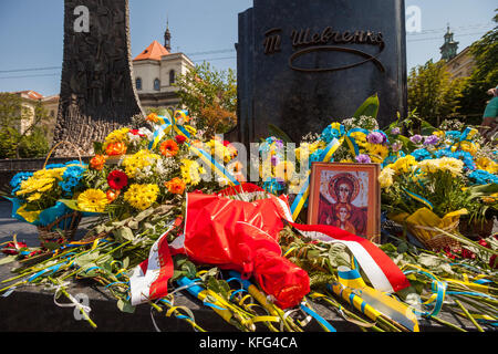 Blumen und religiöse Symbole lag am Fuße des Shevchenko Monument, Lviv, Ukraine Stockfoto