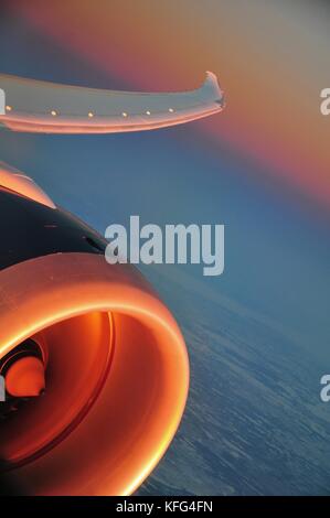 Flugzeug Jet Engine abstrakt mit schönen Himmel Farben im Hintergrund kurz vor Sonnenuntergang. Fliegen 40 000 Fuß über dem Meeresspiegel. Stockfoto