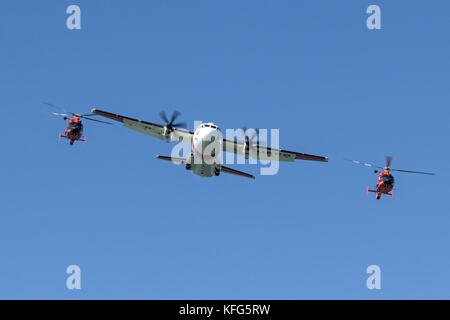 Ein paar der Küstenwache MH-65 Dolphin Helikopter der Air Station San Francisco fliegen in enger Formation mit einem C-27 J Spartan von Air Station Sacramento Stockfoto