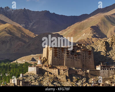 Der alte Königspalast von Leh: Ein großer Ton Gebäude steht unter den Bergen oberhalb der Stadt, weiß buddhistischen Stupas, Ladakh, Nordindien. Stockfoto