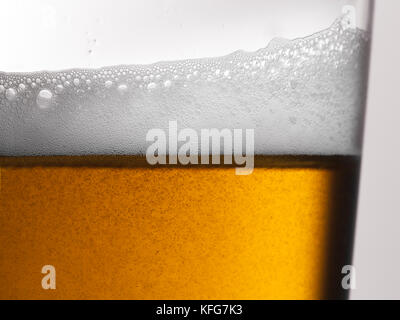 Frisch gegossenes braunes Gold-Bier mit schäumendem Kopf und Bläschen in einem Glas Stockfoto