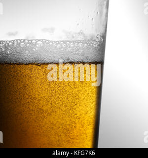 Frisch gelb gold Bier mit schaumigen Kopf gegossen und Blasen in ein Glas Stockfoto