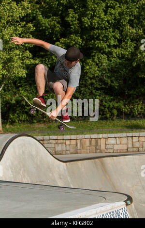 Atlanta, GA, USA - Juli 2, 2017: ein Teenager vervollständigt ein Skateboard Trick, wie er in der Luft erhält verlassen die Schüssel am Alten vierten Station Park. Stockfoto