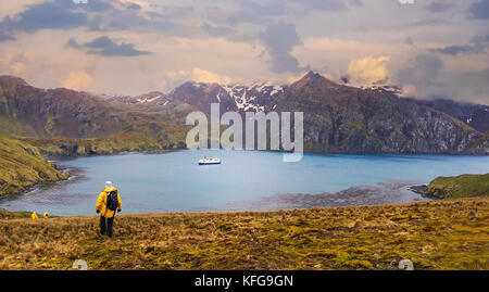 Die Passagiere wieder in ihre antarktisexpedition Schiff in einer ruhigen Bucht vor Anker nach der Erkundung der dramatischen Landschaft von South Georgia Island. Stockfoto