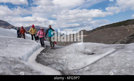 Führt eine Gruppe von bunt gekleideten Touristen auf eine kurze Gletscherwanderung mit blauem Himmel, Landschaften, Flüsse und Gletscher Gipfel Stockfoto