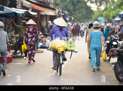 Saigon, Vietnam - 30. Juni 2017: Frau Reiten Fahrrad mit Obst auf Street Market, Saigon, Vietnam. Stockfoto