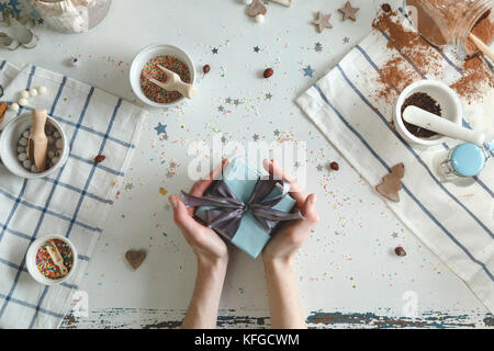 Kreatives Hobby. die Hände der Frau wrap Urlaub handmade in Handwerk Papier mit Garn Ribbon. Stockfoto