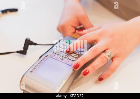 Nahaufnahme der Mädchen Hände Eingabe des PIN-Codes, die Zahlung für den Kauf von banking Magnetkarte. Stockfoto