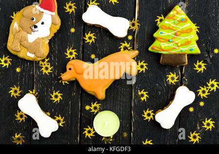 Gelb das Neue Jahr Hund. Cookies mit Schokoladenglasur. Der dunkle Hintergrund mit gelben Sternchen. Stockfoto