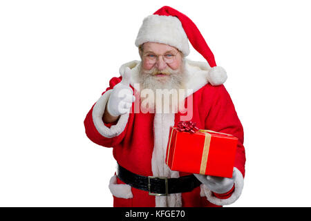 Portrait von Santa Claus mit roter Geschenkbox. santa claus Daumen hoch, Gestik, auf weißem Hintergrund. Studio geschossen von fröhlichen Weihnachtsmann mit Geschenk Stockfoto