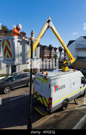 Team der Beleuchtung Vertragspartner gerade ein Erbe Straße Leuchte/Lampe/Strassenlaterne/Gusseisen Beleuchtung Spalte mit einem modernen LED-Licht. London, Großbritannien Stockfoto