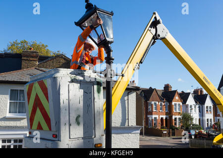 Team der Beleuchtung Vertragspartner gerade ein Erbe Straße Leuchte/Lampe/Strassenlaterne/Gusseisen Beleuchtung Spalte mit einem modernen LED-Licht. London, Großbritannien Stockfoto