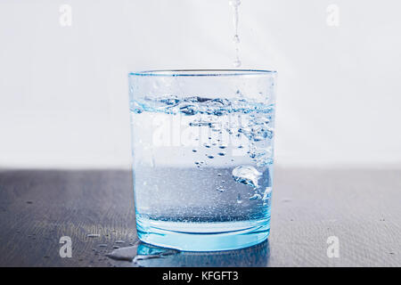 Ein Glas abfüllen von Wasser, in einem High-key-Fotografie mit einem weißen hellen Hintergrund Stockfoto