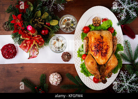 Gebackener Truthahn oder Hähnchen. Weihnachten Tabelle einen Truthahn serviert wird, mit hellen Lametta und Kerzen dekoriert. Fried Chicken, Tisch. Weihnachtsessen Stockfoto