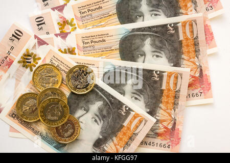 In der Nähe von Royal Bank of Scotland neue Kunststoff Polymer zehn Pfund £ 10 Banknoten- und neuen sechseckigen ein Pfund £ 1 Münzen auf weißem Hintergrund Stockfoto
