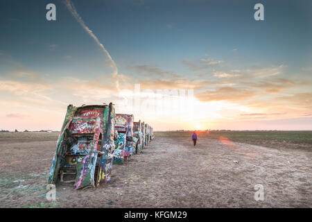 Amarillo, Texas, USA. 18. Oktober 2015. Die Frau zu Fuß durch die Seite der lackierten Fahrzeuge bei Cadillac Ranch Stockfoto