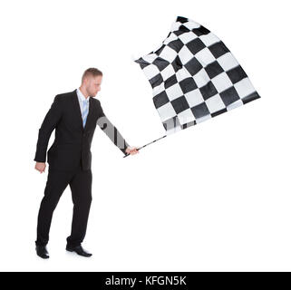 Konzeptionelle Bild eines stilvollen junge Unternehmer winkt ein schwarz-weiß karierte Flagge verwendet als der erfolgreiche Abschluss eines Rennens im Motor Signal Stockfoto