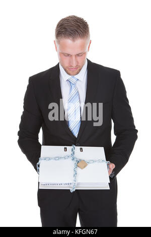 Geschäftsmann mit einem top secret vertrauliche Datei mit einer Kette und einem Vorhängeschloss unbefugten Zugriff isoliert auf weißem gesperrt Stockfoto