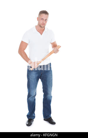 Bully oder Schläger stehen einen Baseballschläger in den Händen hält und mit einem bedrohlichen Blick in die Kamera schaut und bedrohliche Haltung isoliert auf weiss Stockfoto