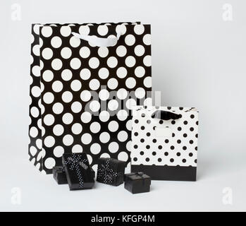 Klein, schwarz Geschenk-Boxen mit schwarzen und weißen Geschenk - Taschen mit Polka Dots, auf weißem Hintergrund. Stockfoto