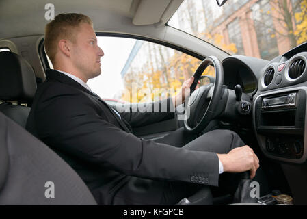 Junger Mann Gangwechsel während der Fahrt ein Auto Stockfoto