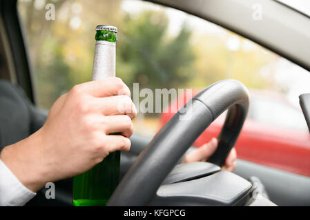 Nahaufnahme Der Hand Eines Mannes in der Bierflasche während der Fahrt Stockfoto