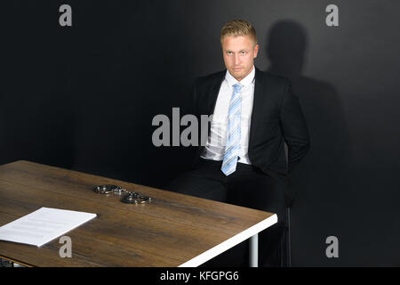 Porträt Eines Jungen Geschäftsmannes, Der Im Verhörraum Sitzt Stockfoto