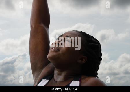 Sportliche afrikanische Frau schwitzen nach dem Training unter Regen über Himmel Hintergrund. weiblichen Athleten nach Arbeit aus. Stockfoto