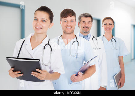 Portrait von Ärzten mit Dokumenten und digitalen Tablet stehen in der Zeile am Krankenhaus Stockfoto