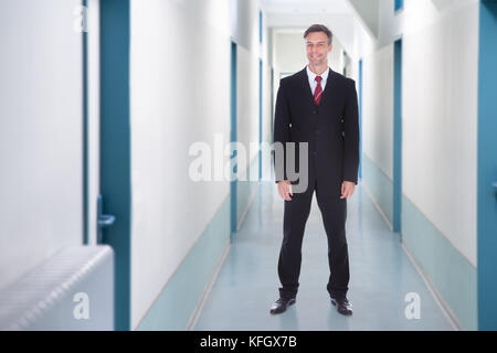 Volle Länge Portrait von Happy Geschäftsmann im Büro Flur Stockfoto