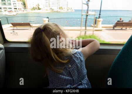 Drei Jahre altes Mädchen/Kind/Passagier/Passagiere auf einen öffentlichen Bus/mit öffentlichen Verkehrsmitteln in St. Julians Bay/St. Julian's Bay Malta reisen. Stockfoto