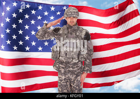 Portrait von amerikanischer Soldat salutierte vor der Flagge Stockfoto