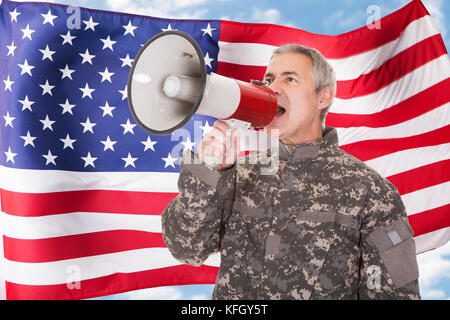 Soldat anschreien durch Megaphon vor USA-Flagge Stockfoto