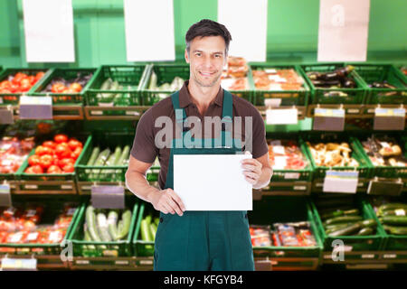 Reifer Verkäufer mit einem leeren Schrank im Supermarkt Stockfoto