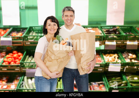Happy Älteres Paar hält Eine Lebensmitteltasche im Supermarkt Stockfoto
