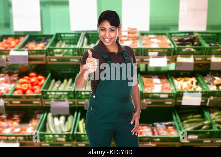 Junge Verkäuferin Zeigt Geste Mit Dem Daumen Nach Oben Im Supermarkt Stockfoto