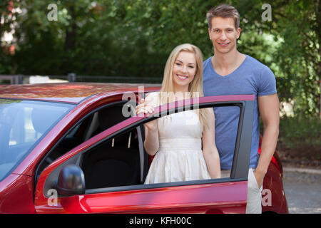 Portrait von glückliches junges Paar steht die neue Auto Tür Stockfoto