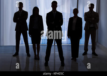 Silhouette-Team von Geschäftsleuten zusammen stehen im Büro Stockfoto