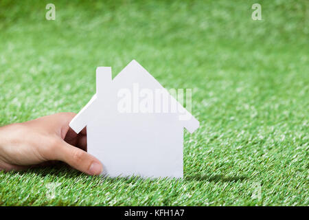 Nahaufnahme der Hand Mann mit Haus im grünen Bereich Stockfoto