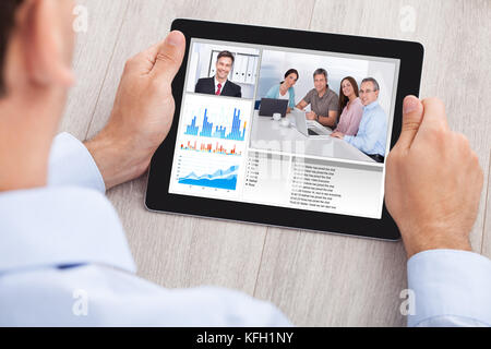 Bild von Geschäftsmann Videokonferenzen mit Team auf digital-Tablette am Schreibtisch im Büro beschnitten Stockfoto