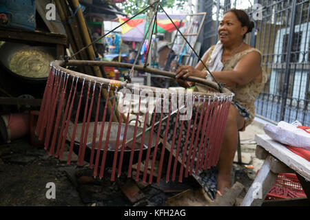 Eine philippinische Frau, die Kerzen zur Vorbereitung auf Allerheiligen, All Souls Day, Cebu City, Philippinen, macht Stockfoto