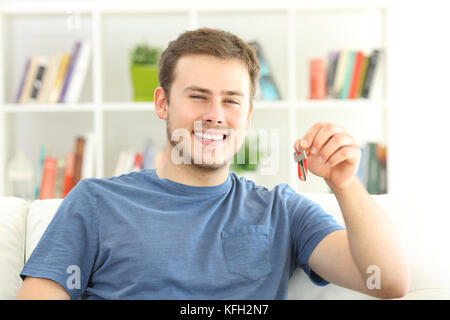 Stolz home Eigentümer holding Hausschlüssel sitzen auf einem Sofa Stockfoto