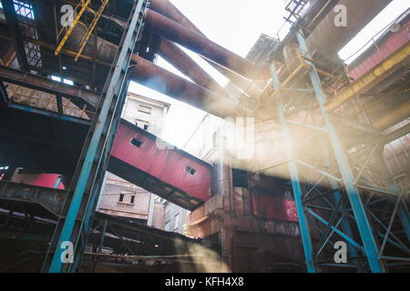 Die Wellen des Lichtes zwischen alten Rohre einer verlassenen Fabrik in Peking, China scheint. Stockfoto