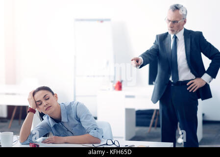 Angry Chef an müde weibliche Büroangestellte schreien Stockfoto